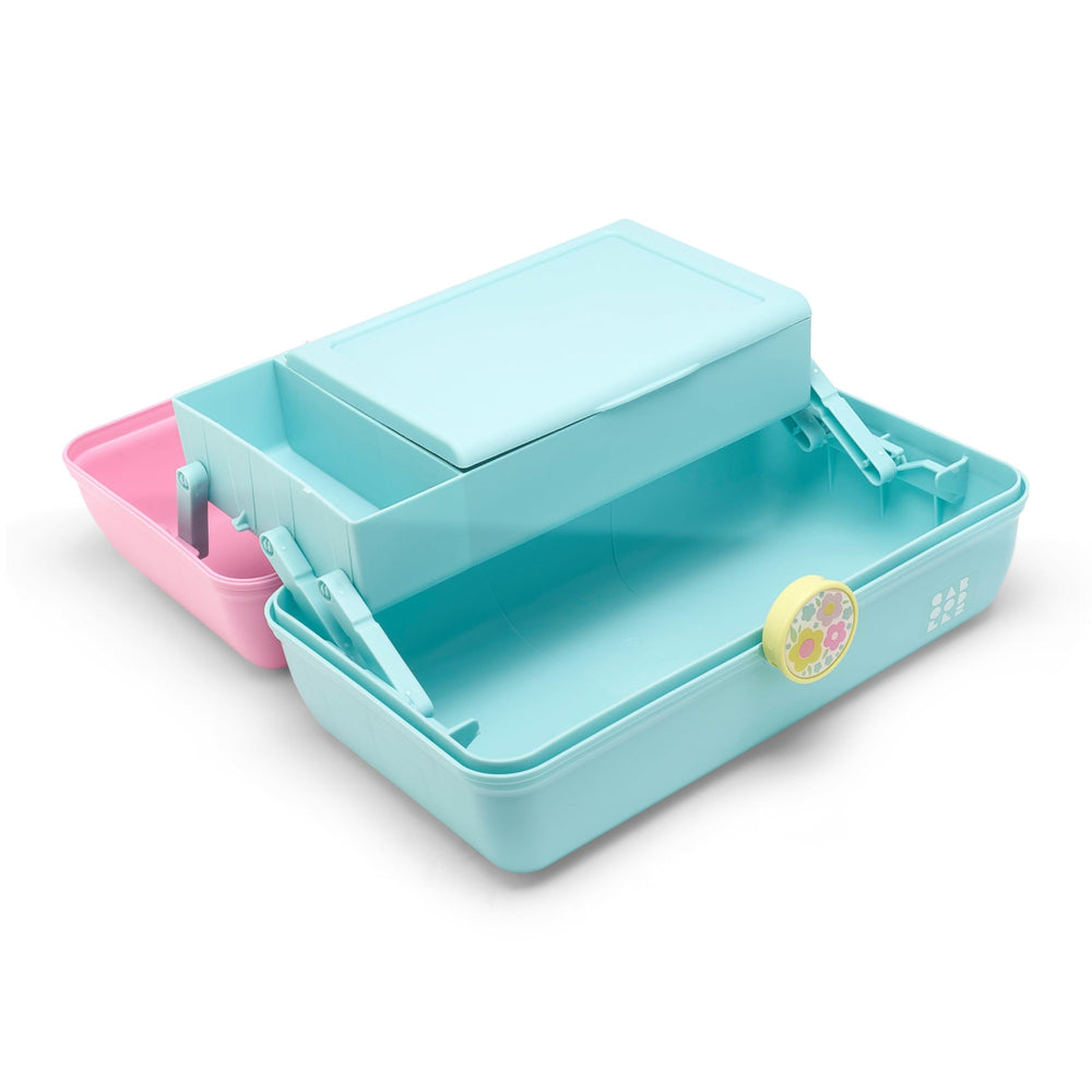Caboodles next to makeup brushes showing scale and roomy lower compartment