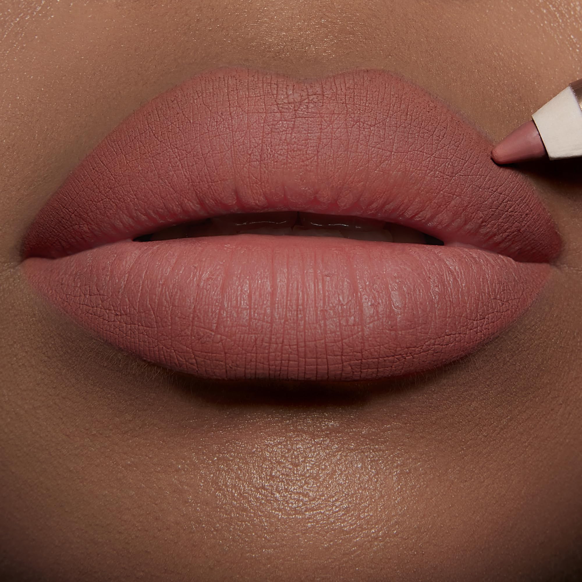 Charlotte Tilbury lip application close-up showing defined edges and natural fuller look