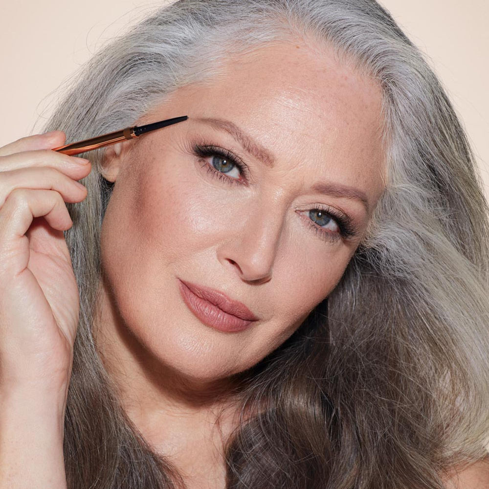 Charlotte Tilbury pencil held in hand to show scale and effortless application benefit