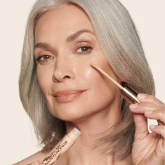 Charlotte Tilbury concealer applied under eye, demonstrates brightening benefit