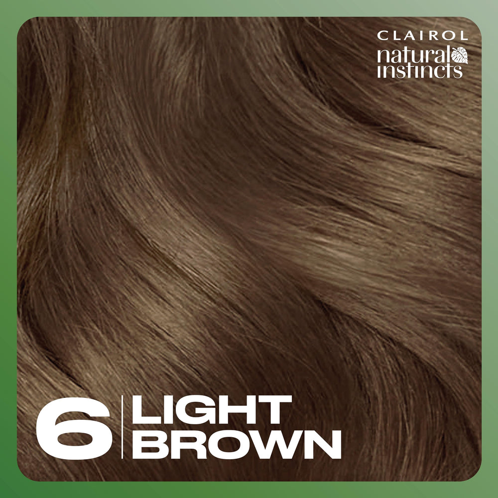 Clairol Natural Instincts kit beside a hand for size and scale clarity