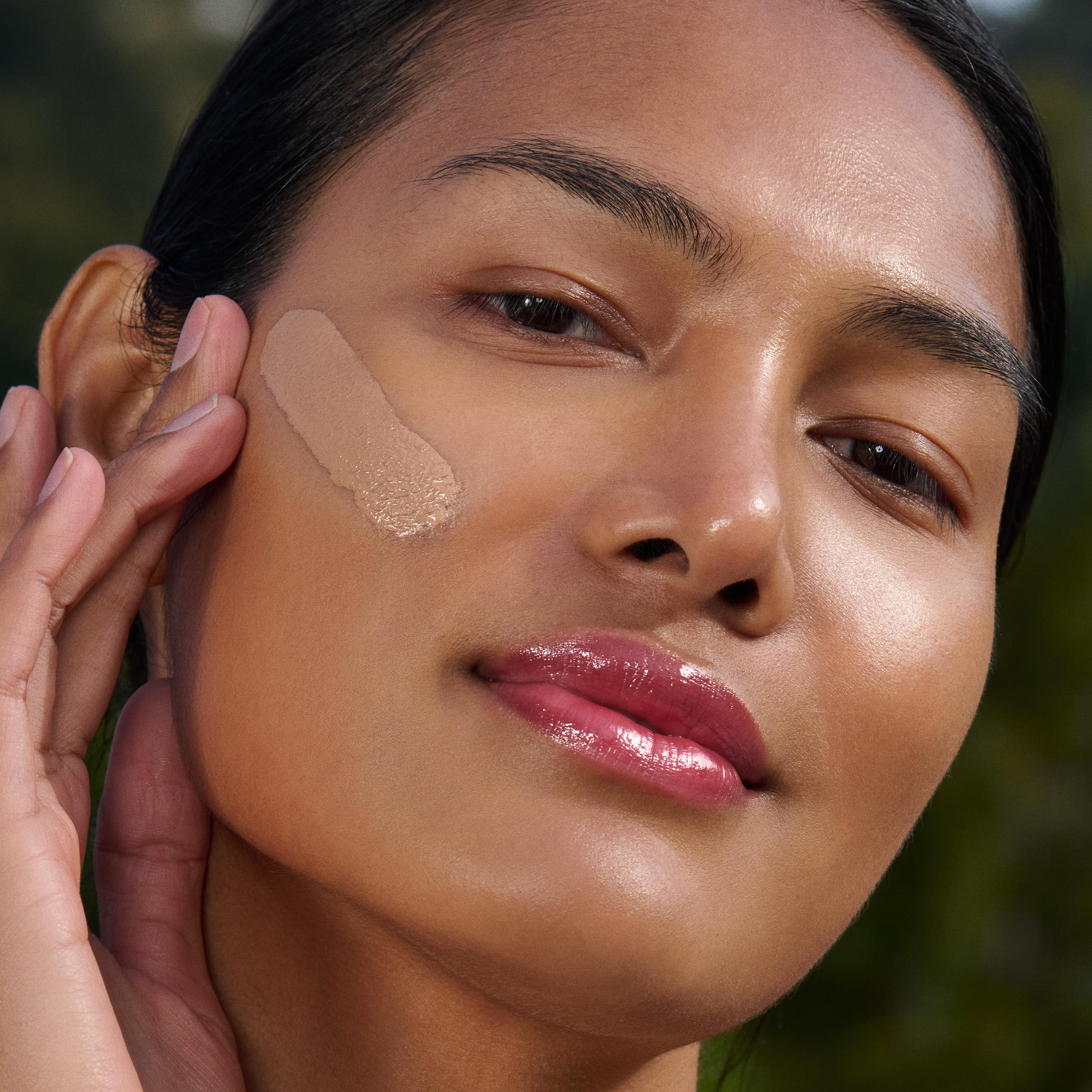 Clarins applied on hand while pressing to face showing easy application benefit