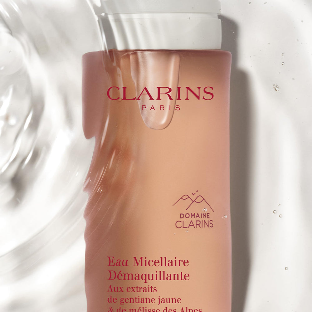 Clarins bottle beside travel items showing convenient on-the-go benefit