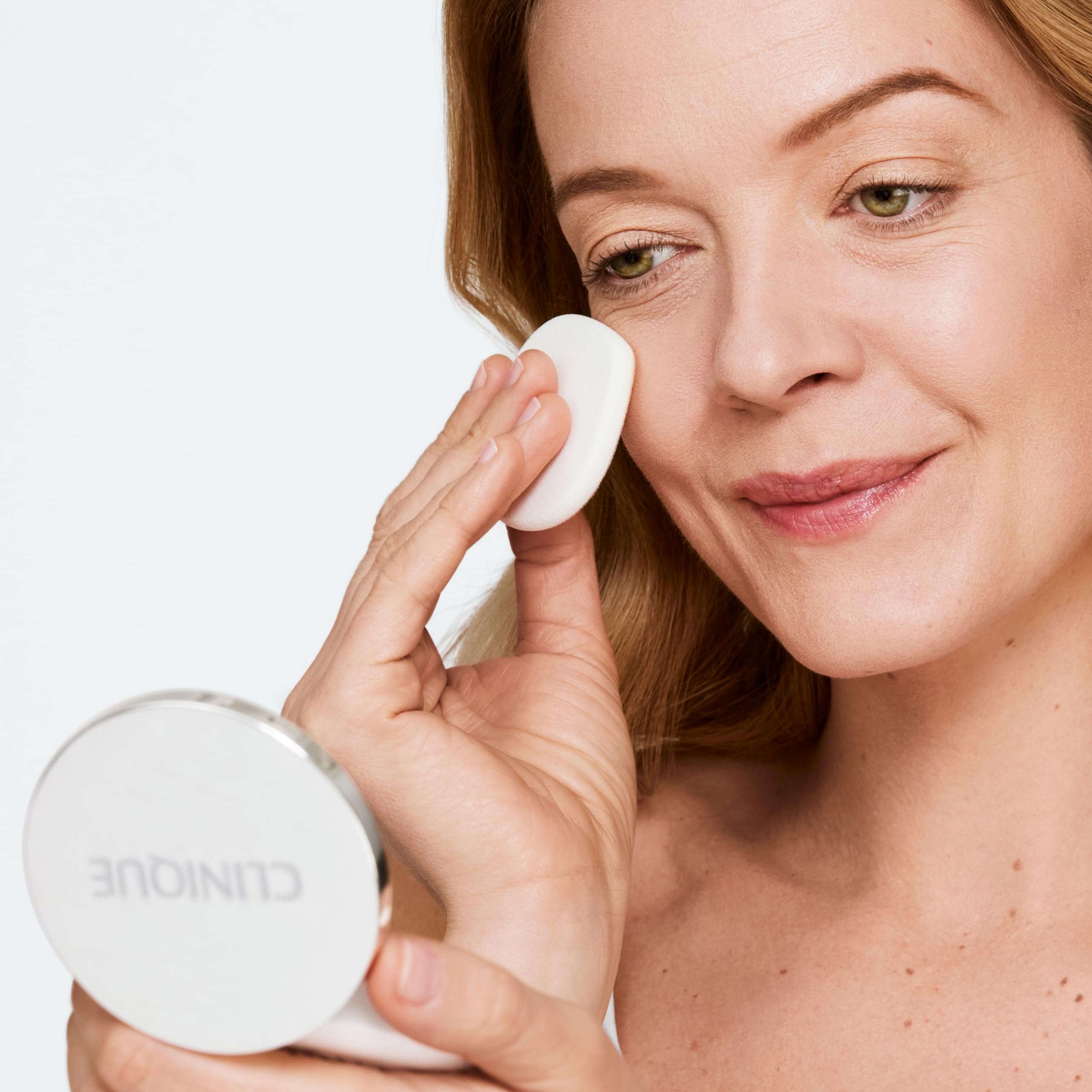 Clinique compact held in hand to show size and portability for on-the-go use