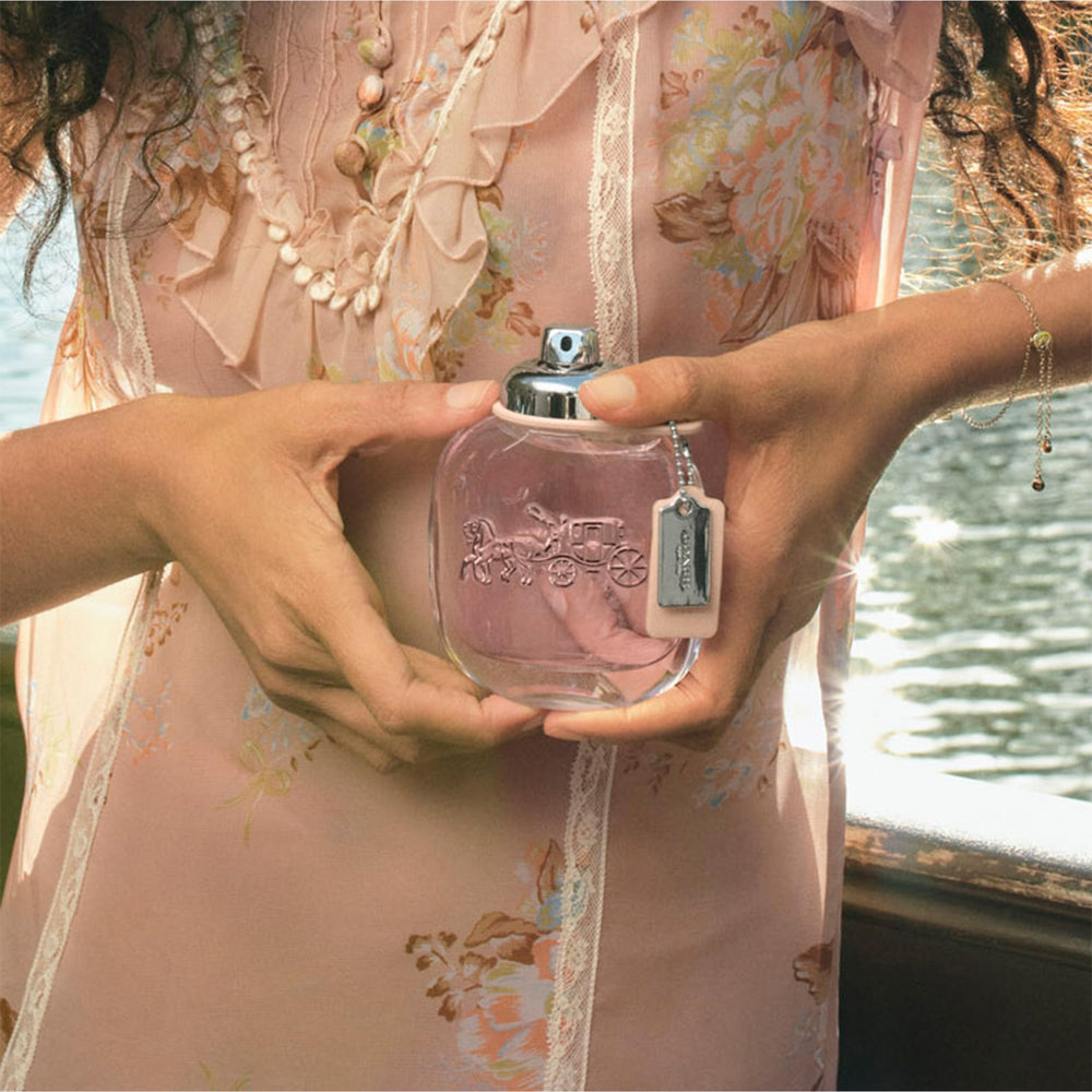 Coach perfume on dresser at sunrise conveying fresh energetic mood
