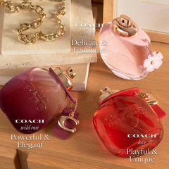 Coach Wild Rose purse spray being applied from a hand, Coach convenience for touch-ups