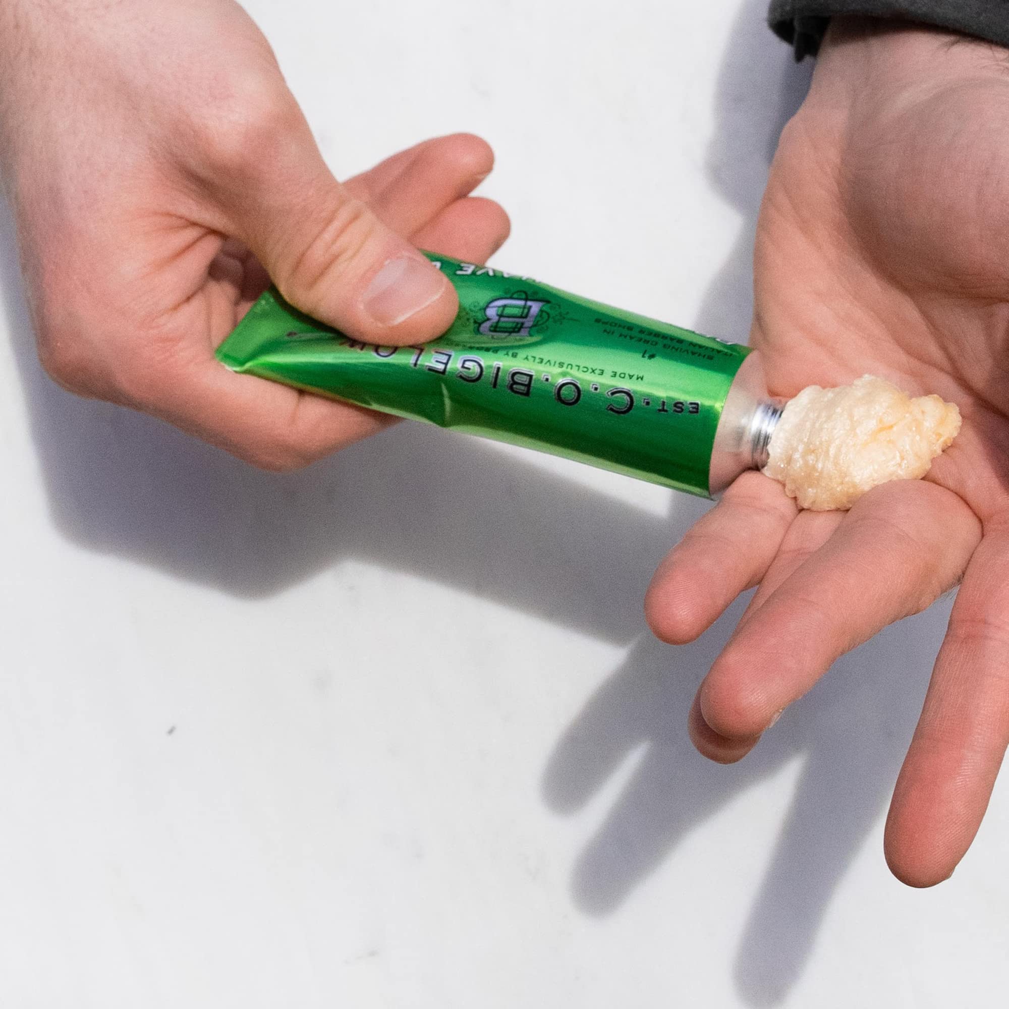 Shaving brush applying C. O. Bigelow cream to face illustrating thicker protective lather