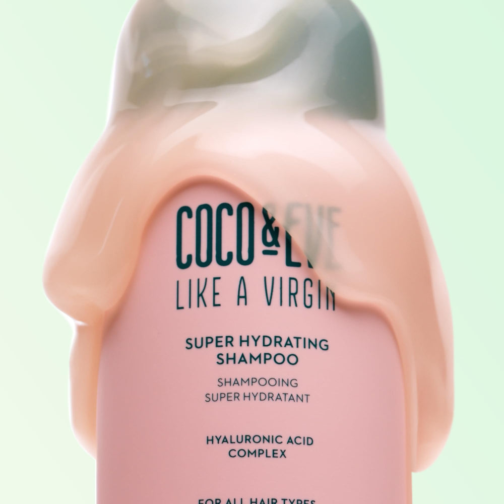 Hand holding Coco & Eve bottle to show 9.47 fl oz scale and portability