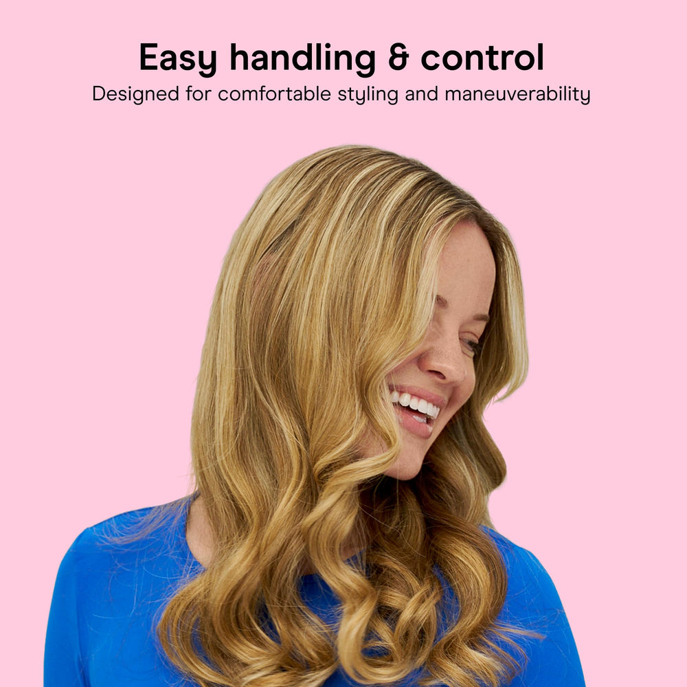 Conair curling iron next to a hand to show compact size and easy travel benefit