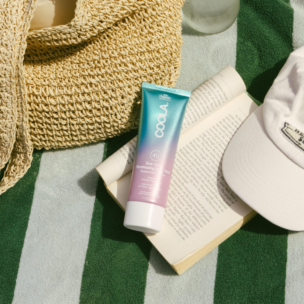 COOLA bottle in beach setting suggesting sun protection on the go benefit