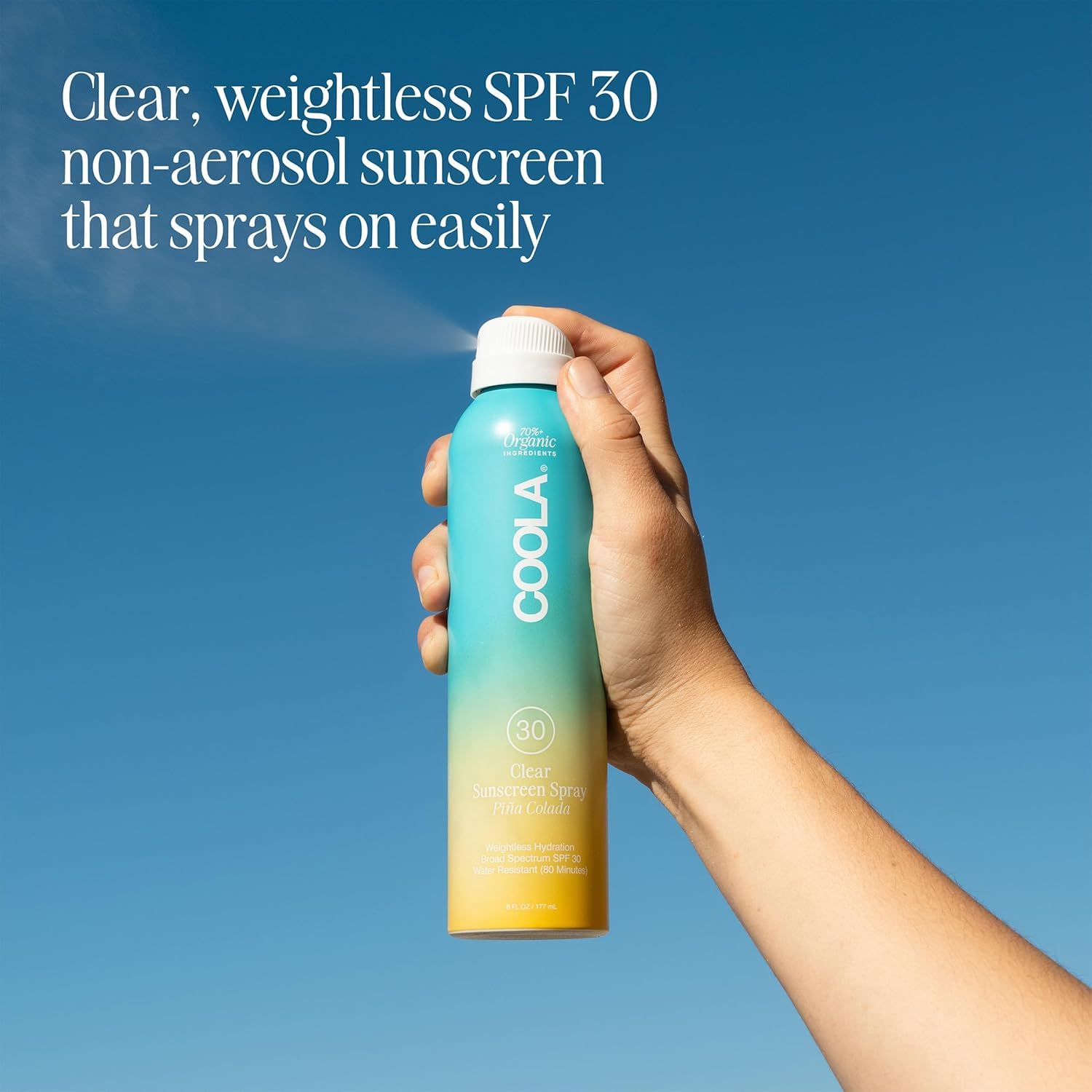 COOLA spray mist in air demonstrating even coverage and fast application benefit