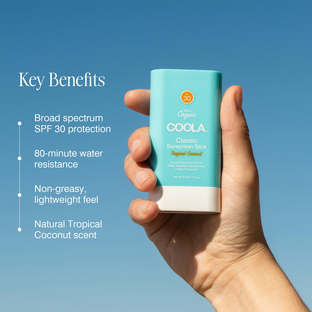 COOLA sunscreen stick in hand to show compact size and easy portability benefit