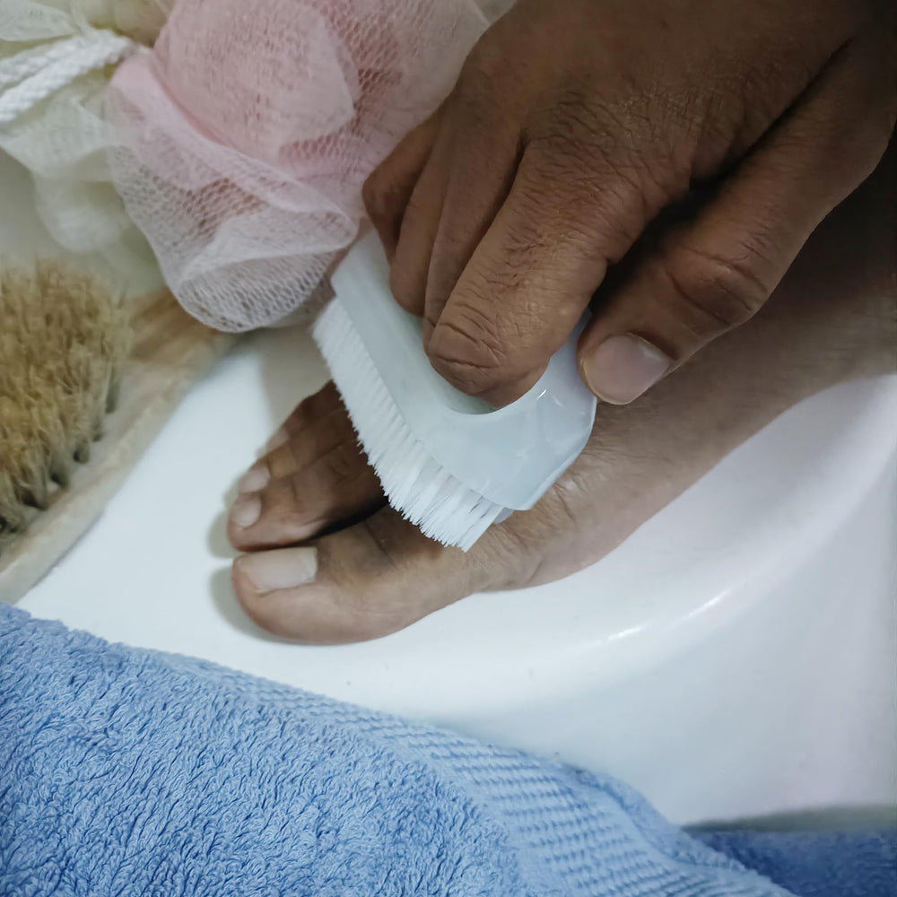 Coralpearl brush cleaning a toenail showing targeted hygiene use
