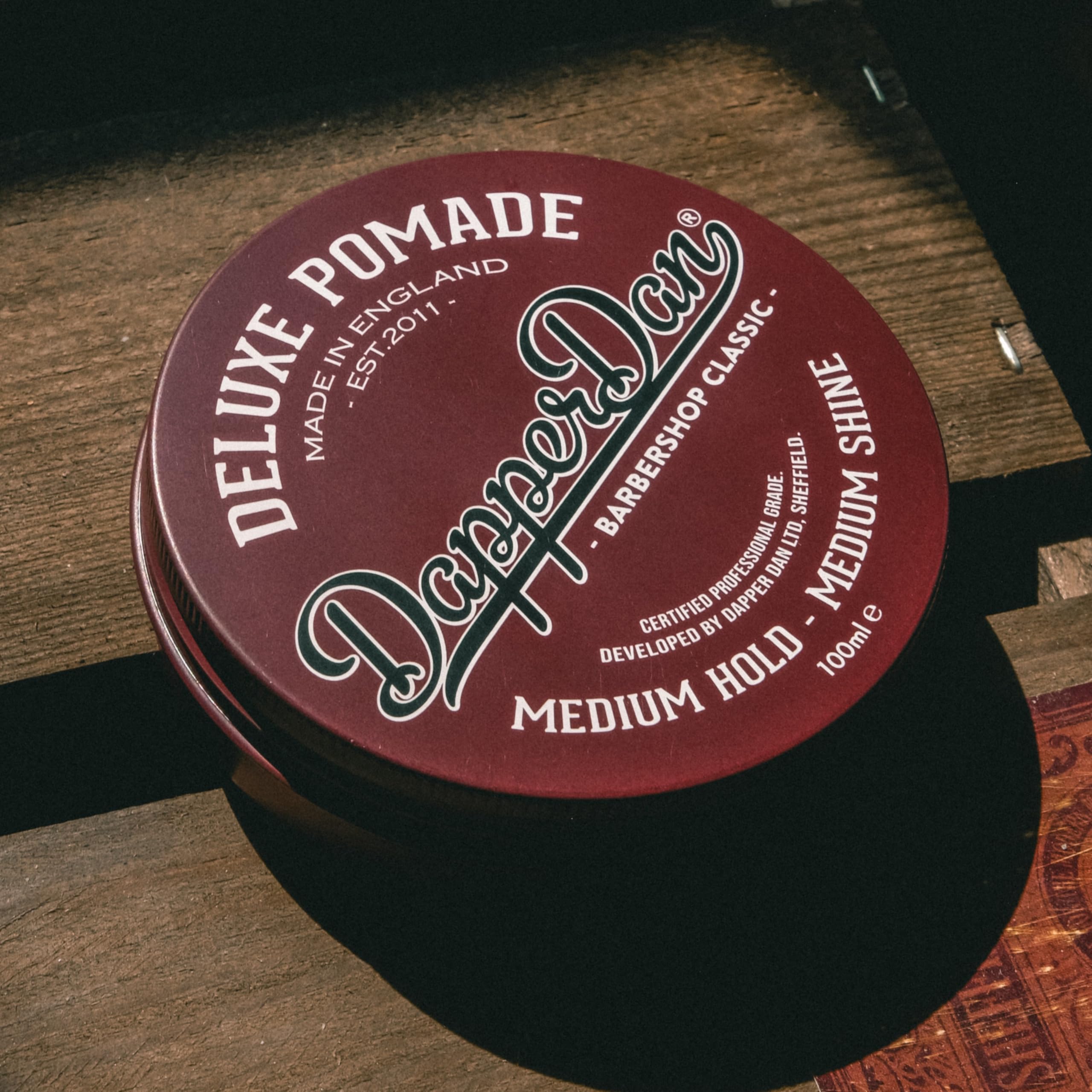 Dapper Dan 100ml pomade next to common bottle to show compact travel-friendly size