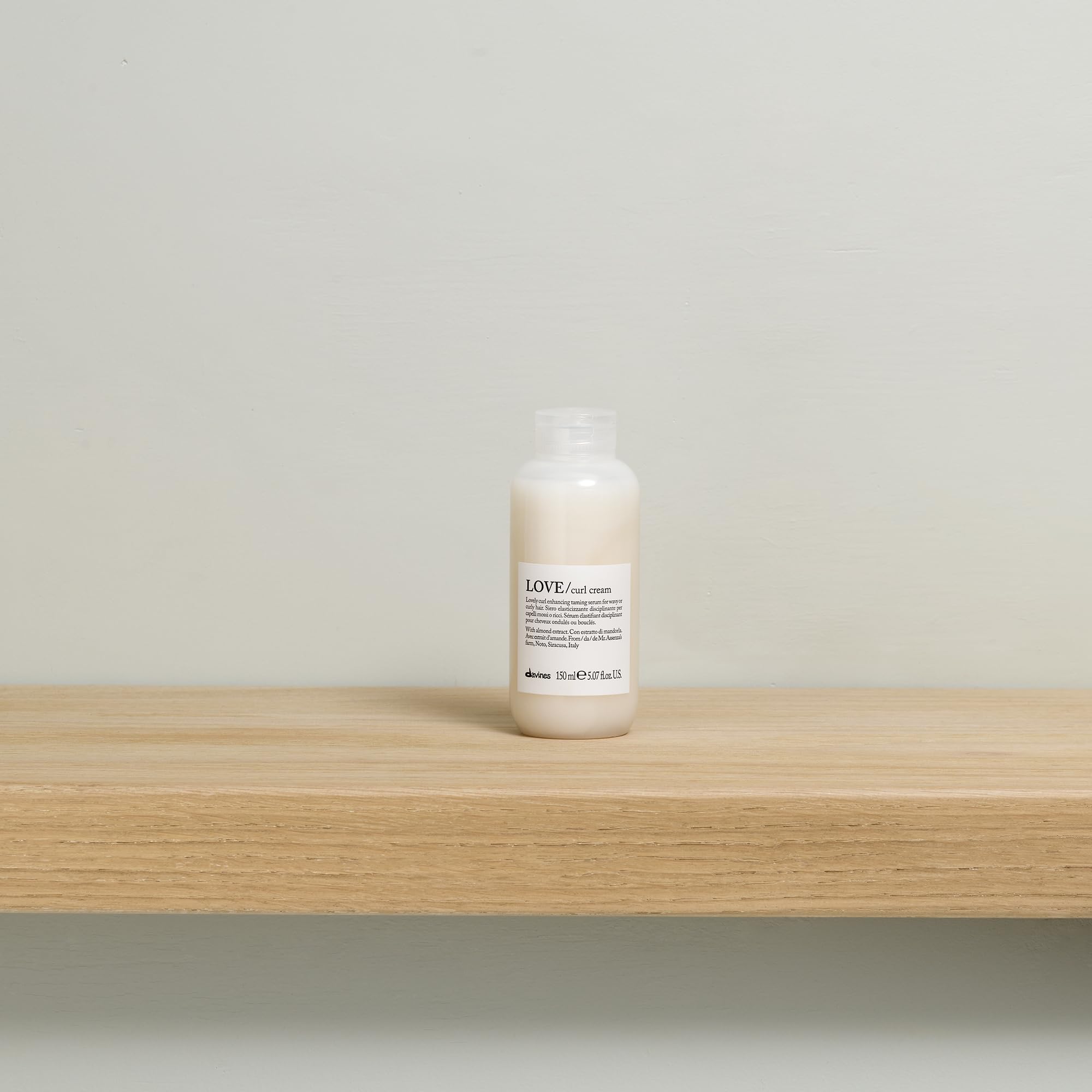 Davines applying cream to damp curls to illustrate definition and frizz reduction benefits