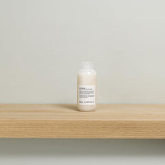 Davines applying cream to damp curls to illustrate definition and frizz reduction benefits