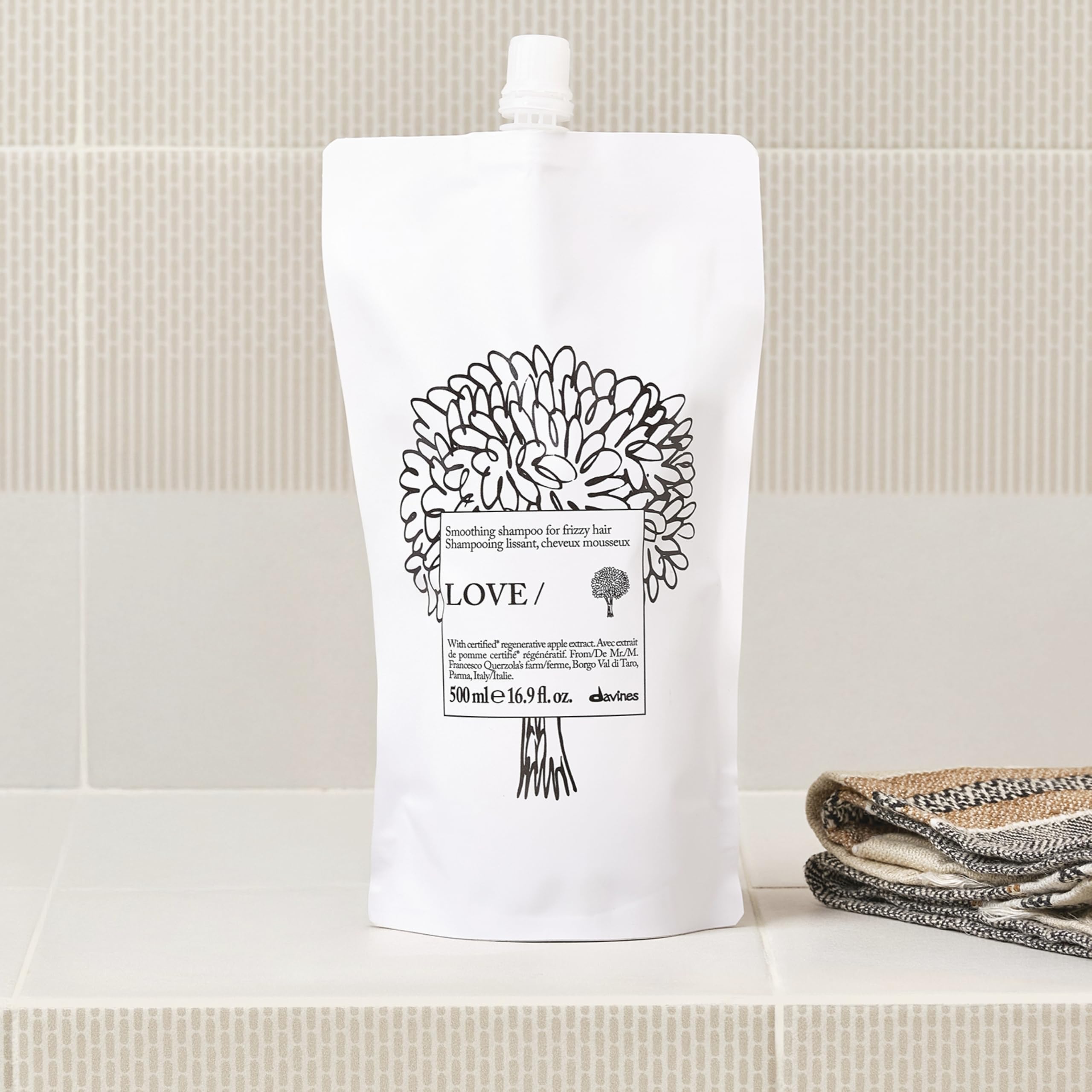 Davines refill being poured into bottle demonstrating easy refill benefit