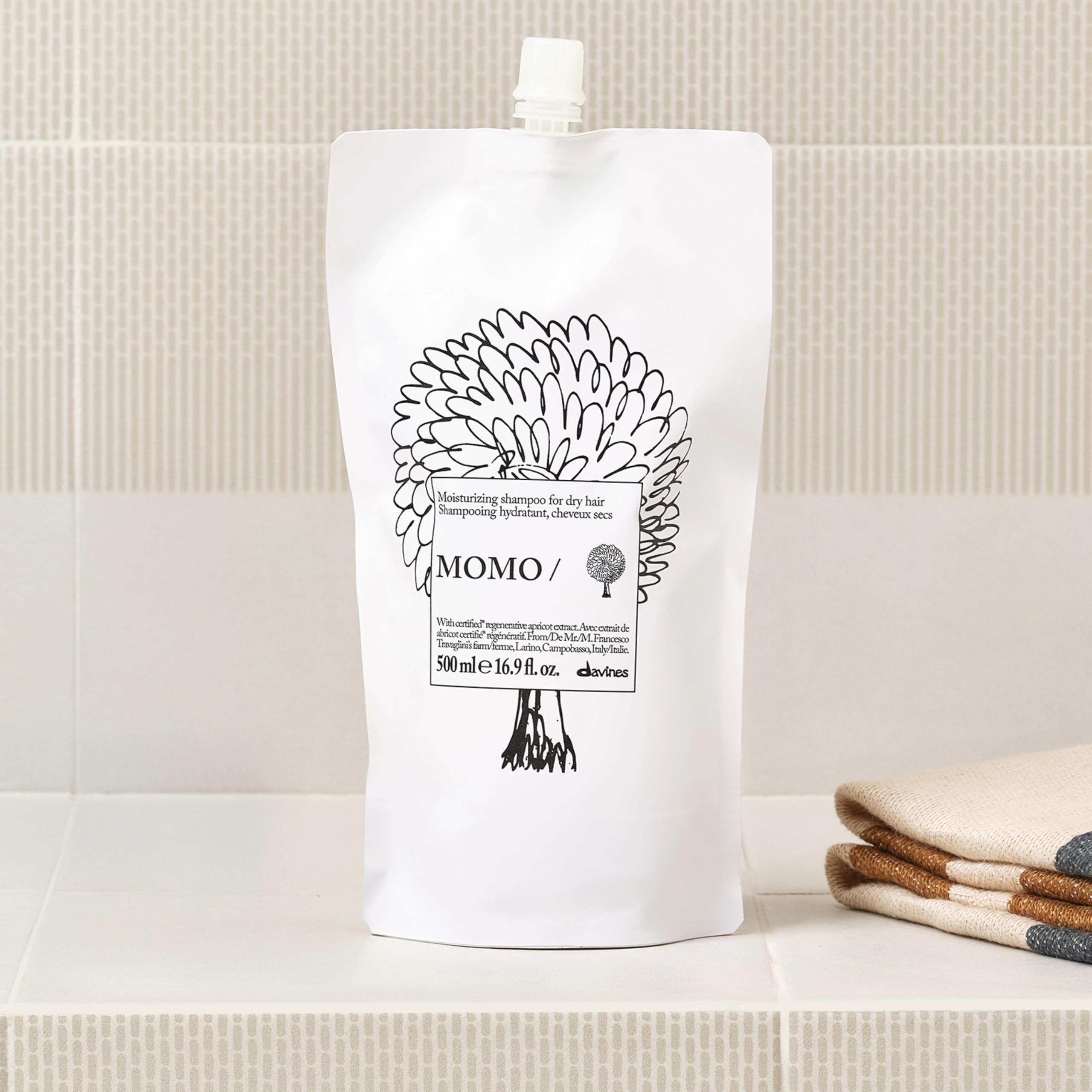 Davines MOMO shampoo lather in hands demonstrating gentle cleansing benefit