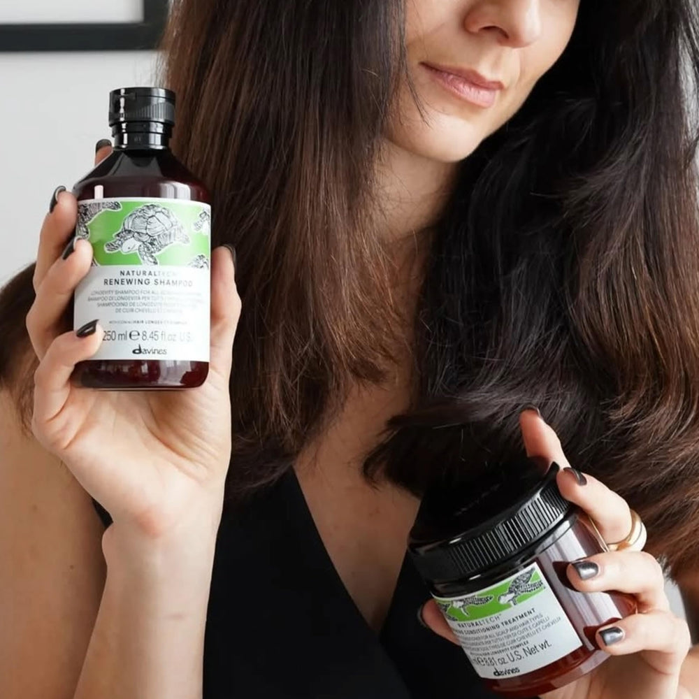 Davines 250ml bottle next to hand depicting true size and travel-friendly benefit