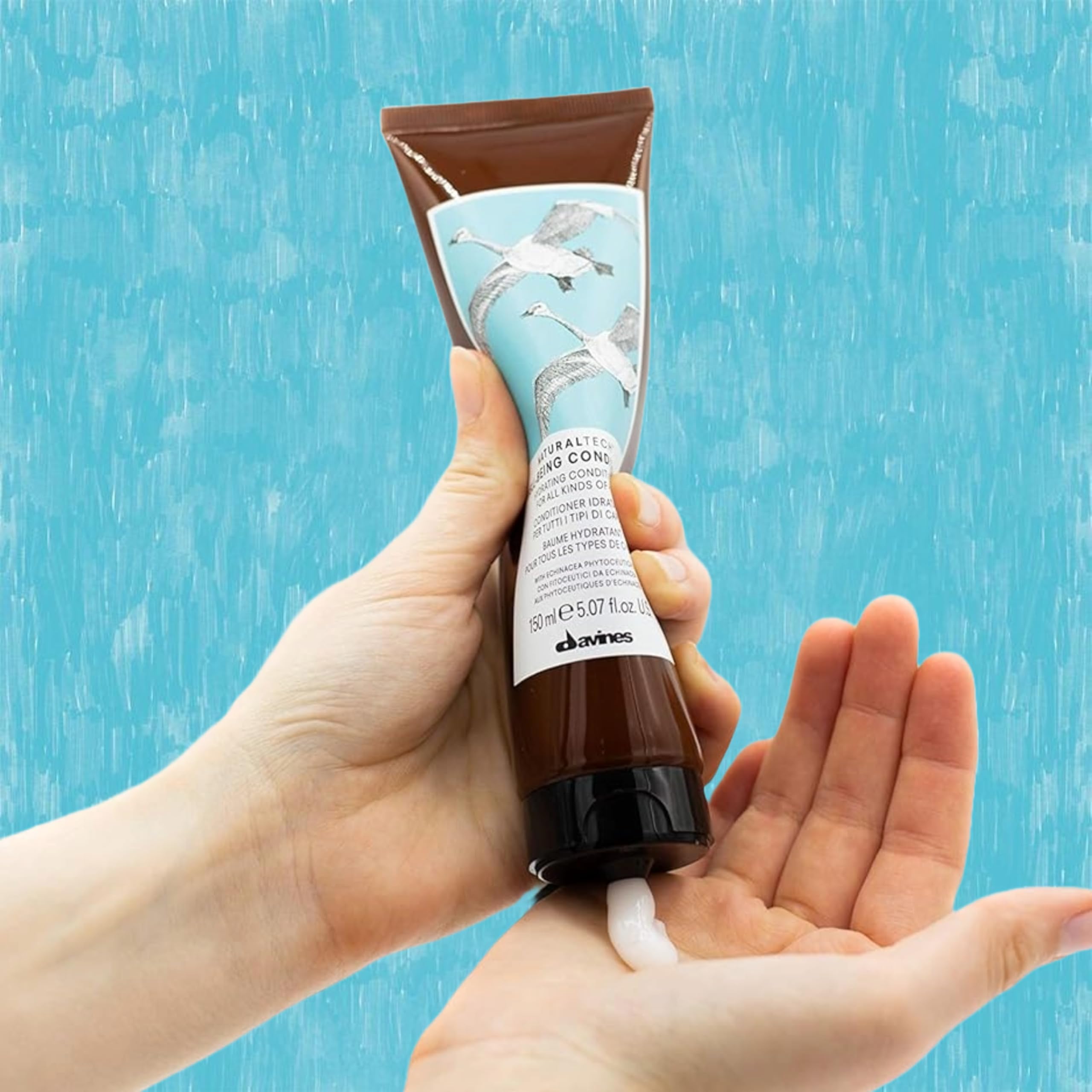 Davines wellbeing conditioner being applied to hair mid-lengths for easy detangling benefit