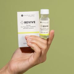 Hand holding Dazzle Dry Revive bottle for size comparison and convenience
