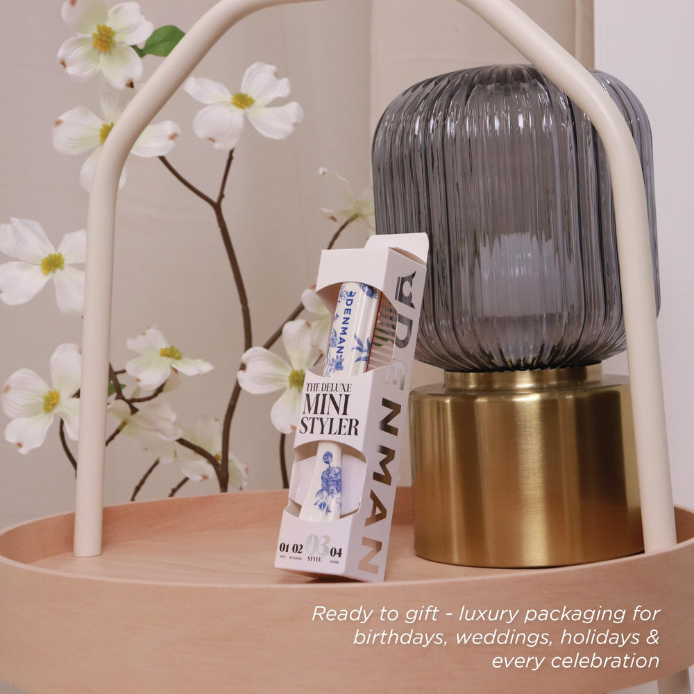 Denman brush held in hand to show compact size and travel convenience