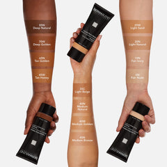 Dermablend applying foundation with brush on leg for even concealment