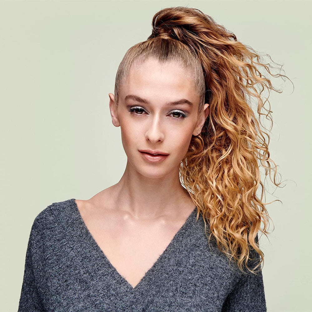 DevaCurl 10 fl oz beside a hand showing size and travel-friendly benefit