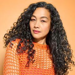 DevaCurl applied to damp curls while scrunching showing improved clumping benefit