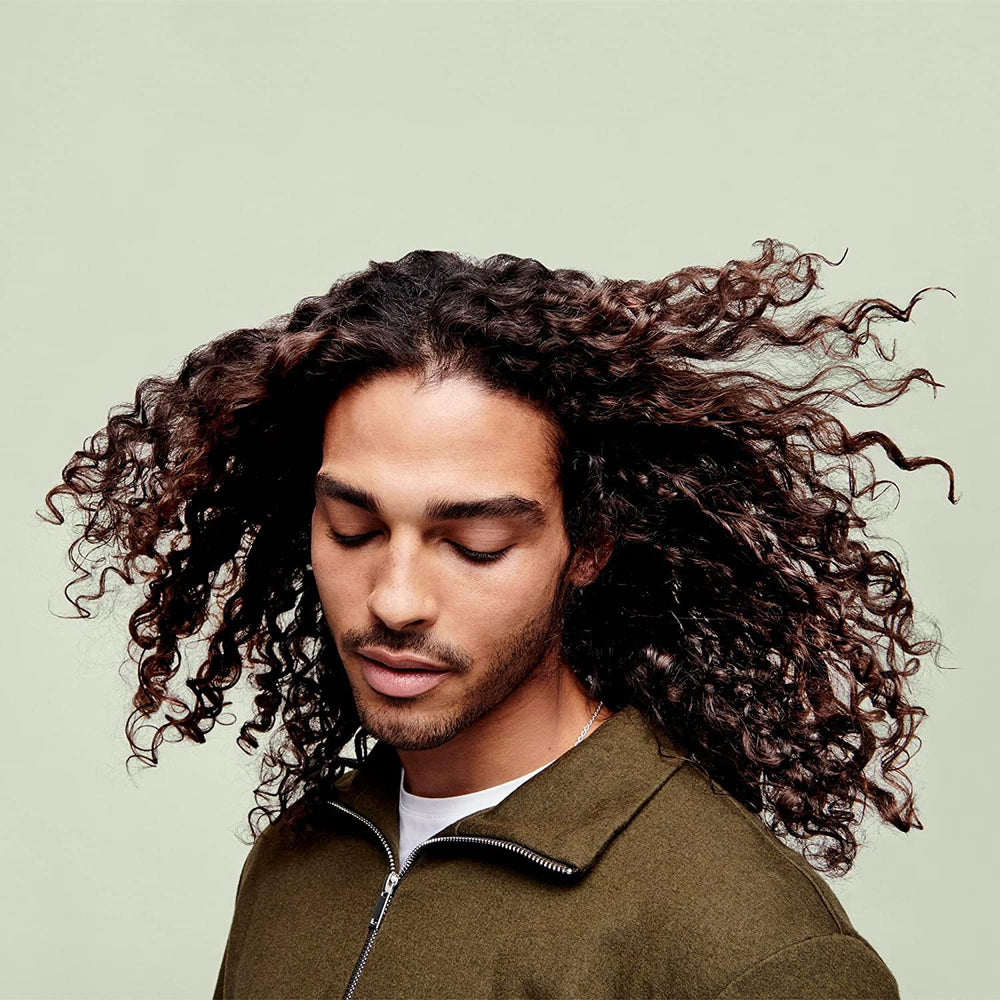 DevaCurl 12 fl oz bottle beside hand showing true product scale