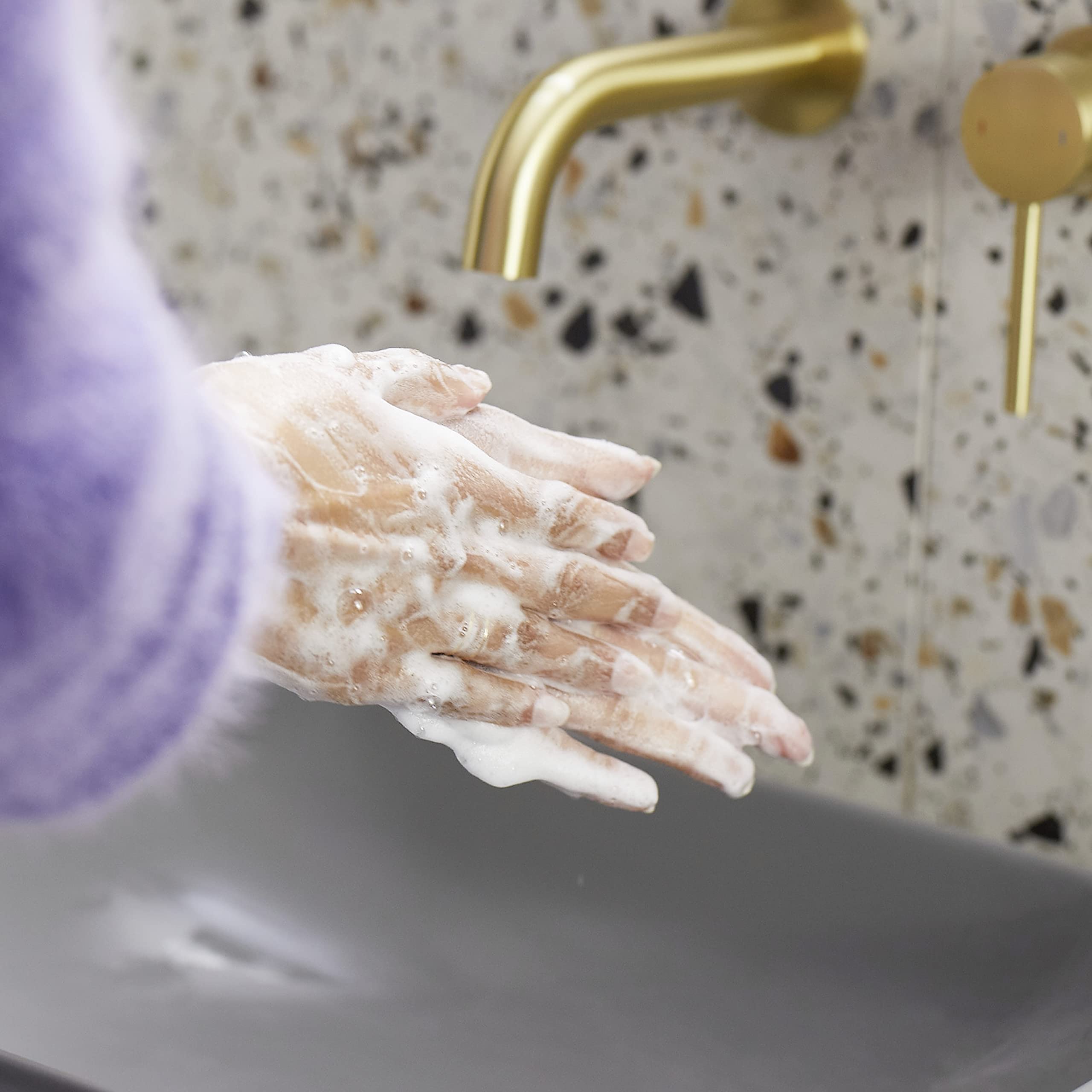 Dove hand wash refill placed in bathroom illustrating soft-skin benefit