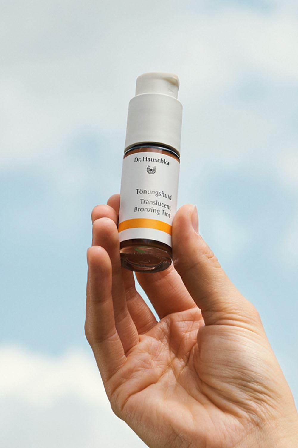 Dr. Hauschka bottle next to a coin to show 0.6 fl oz size and portable convenience