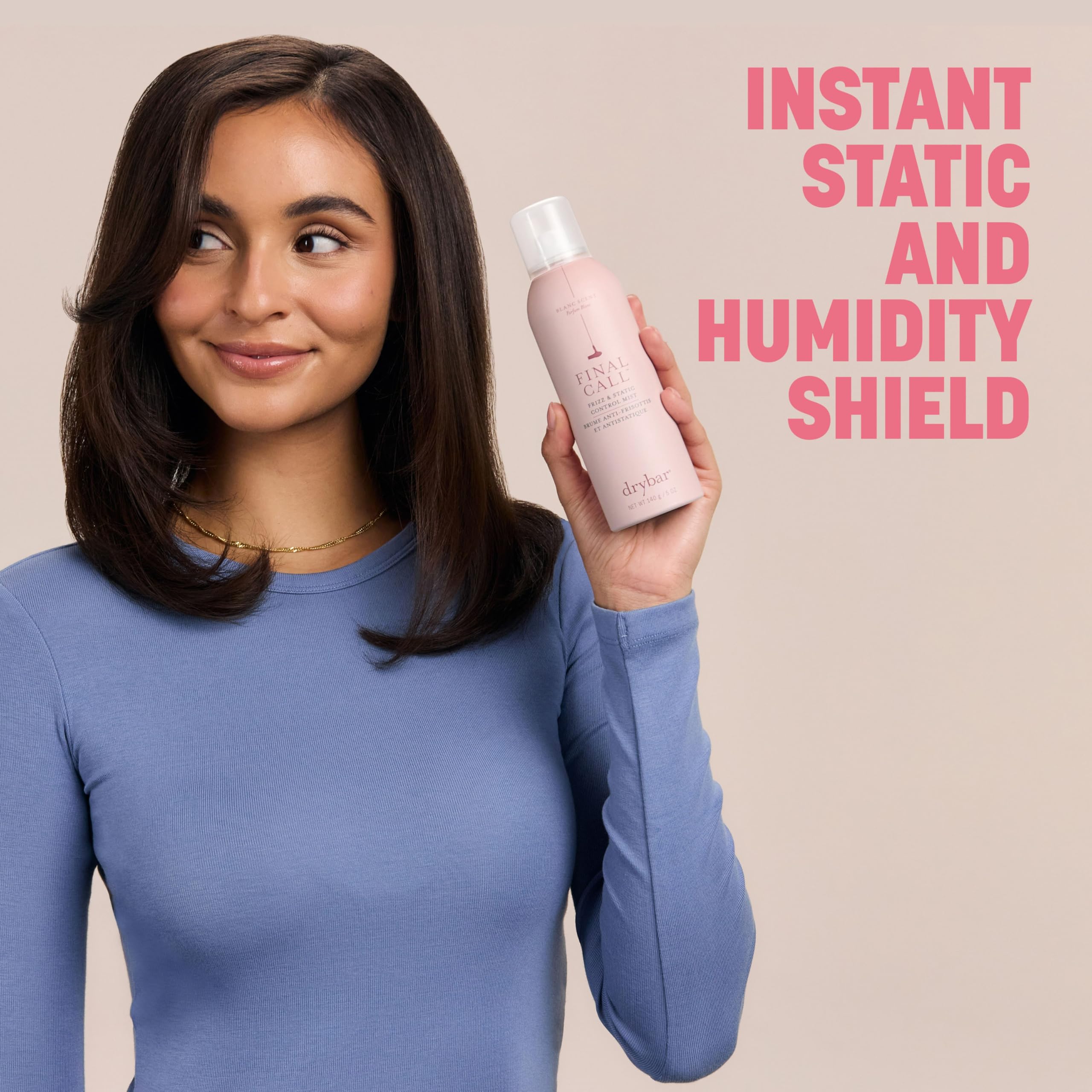Woman outdoors holding Drybar mist demonstrating humidity resistance and shine