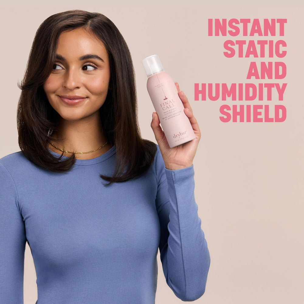 Woman outdoors holding Drybar mist demonstrating humidity resistance and shine