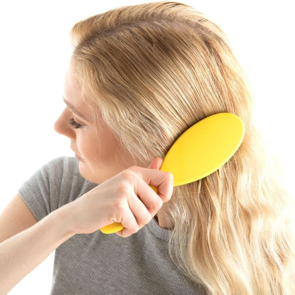 Drybar Super Lemon Drop in hand to show size and ergonomic grip for controlled styling