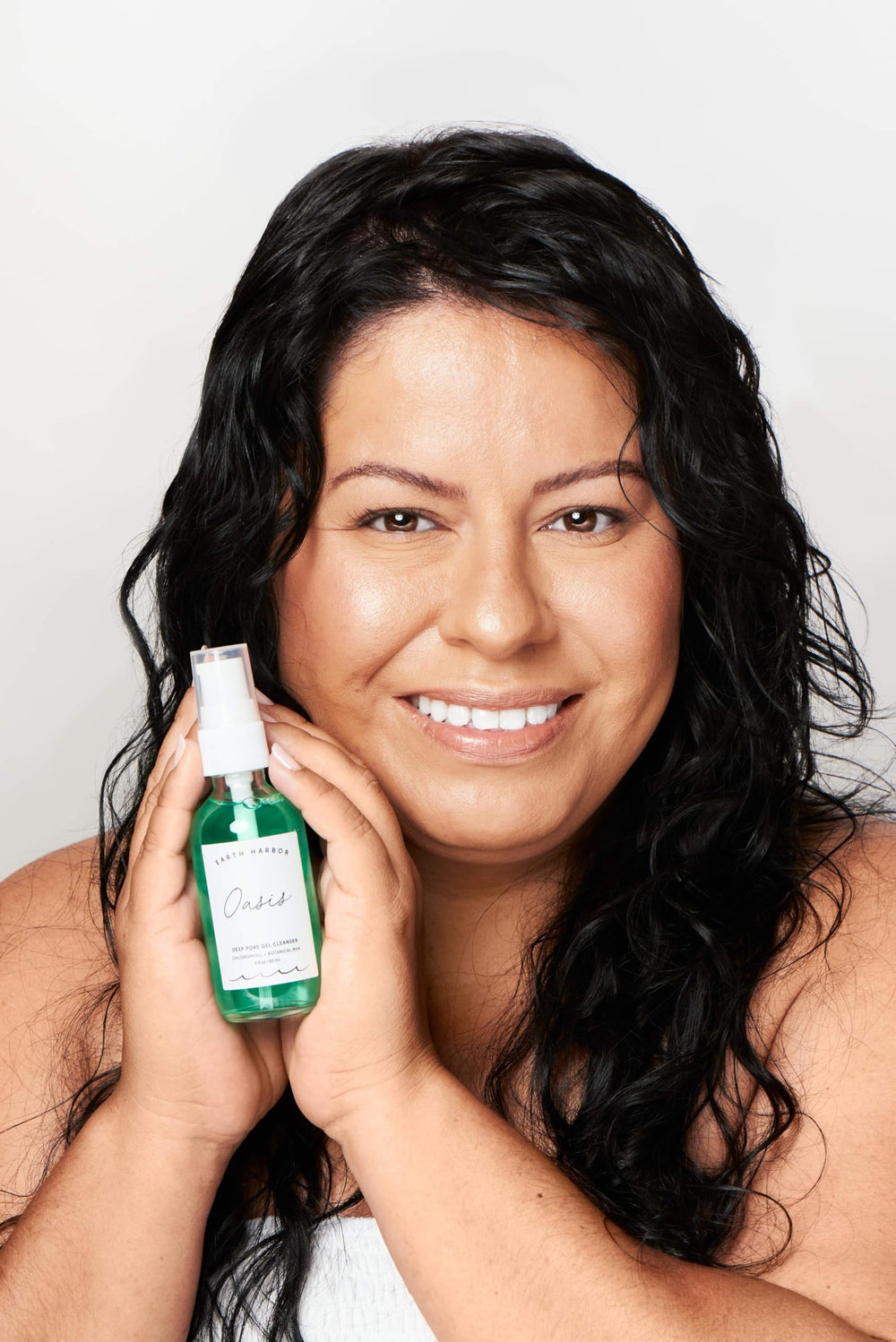 Earth Harbor size scale bottle in hand illustrating compact, travel-friendly volume