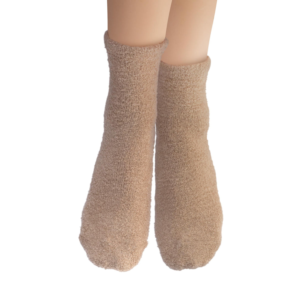 Earth Therapeutics socks worn on feet in bedroom promoting overnight hydration and comfort
