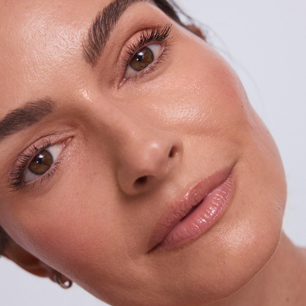 EarthsCure applying cream stick to cheek for instant natural radiance
