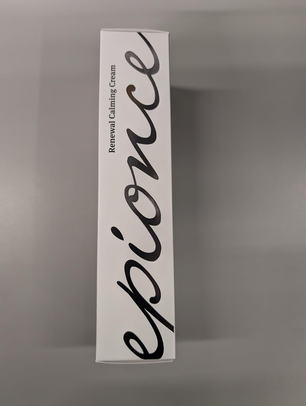 Epionce Renewal Calming Cream jar next to coin for size comparison and travel-friendly benefit