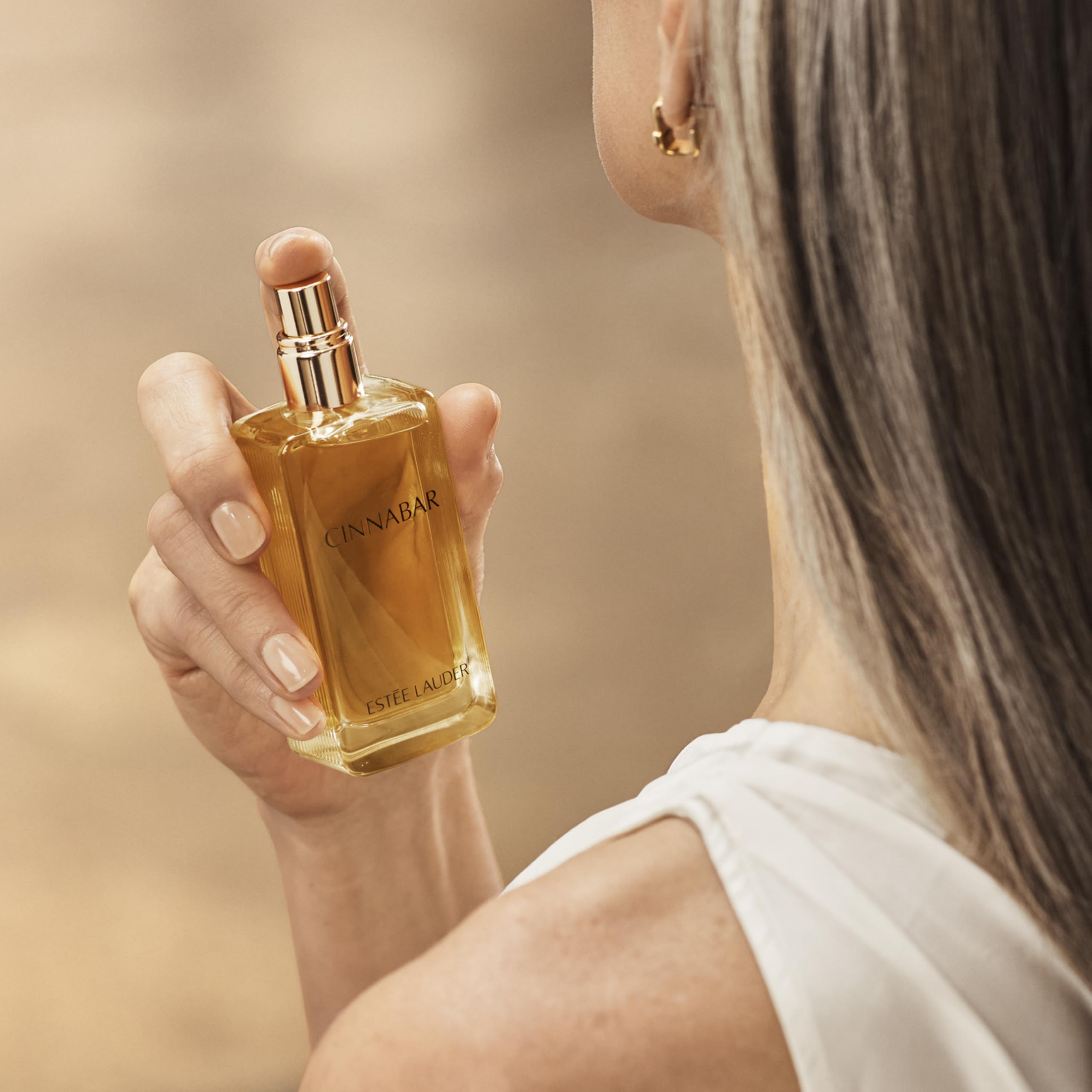 Estée Lauder Cinnabar spray on wrist showing scent testing and wear preview benefit