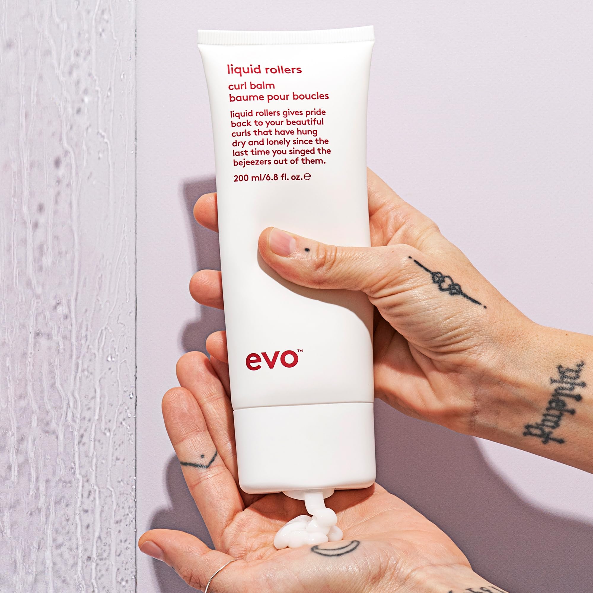 EVO Liquid Rollers next to a hand for scale showing travel-friendly 6.8 fl oz