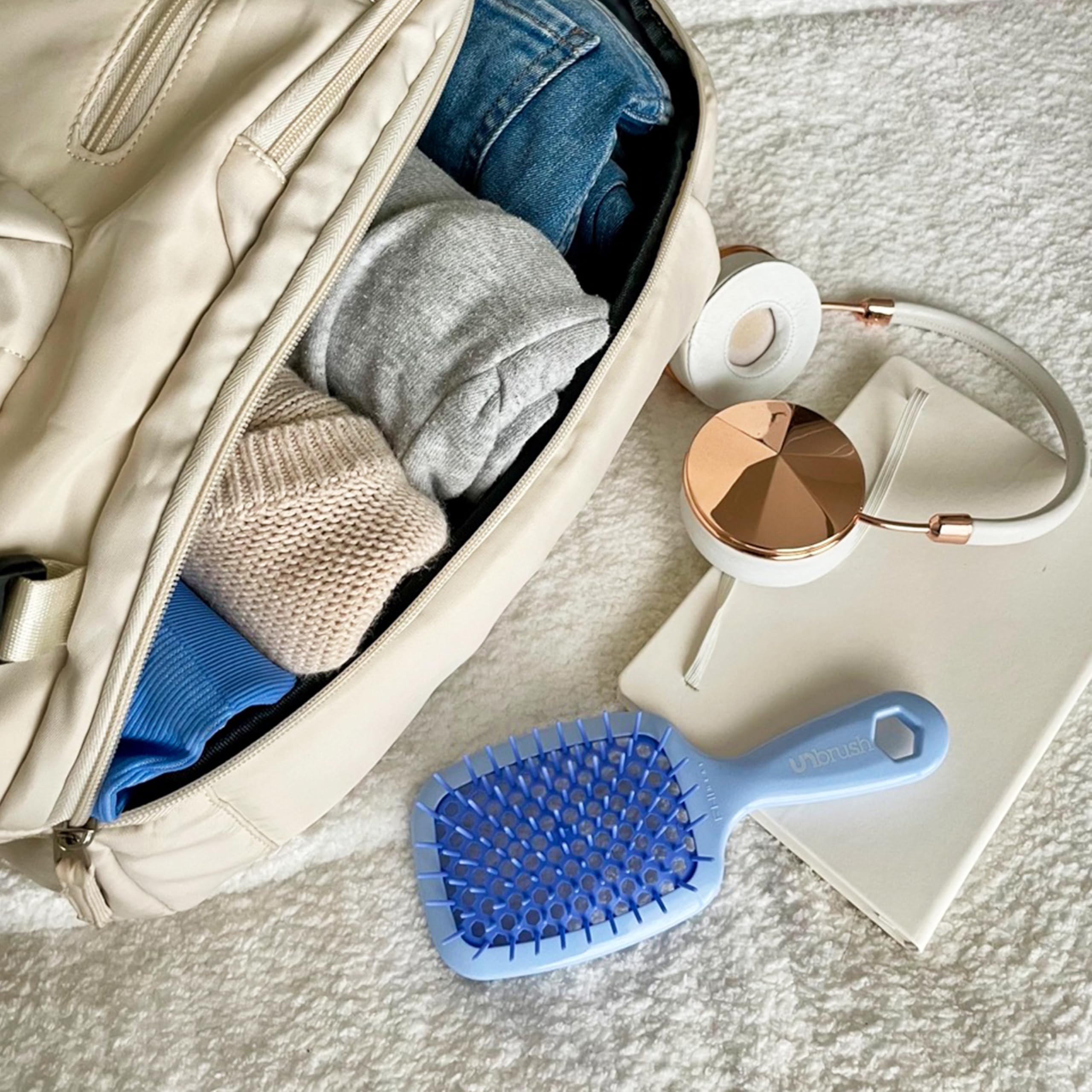 FHI Heat UNbrush on-the-go lifestyle image in a bag showing portability and quick fixes