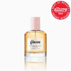 Gisou mist spraying from bottle demonstrating fine even distribution for shine