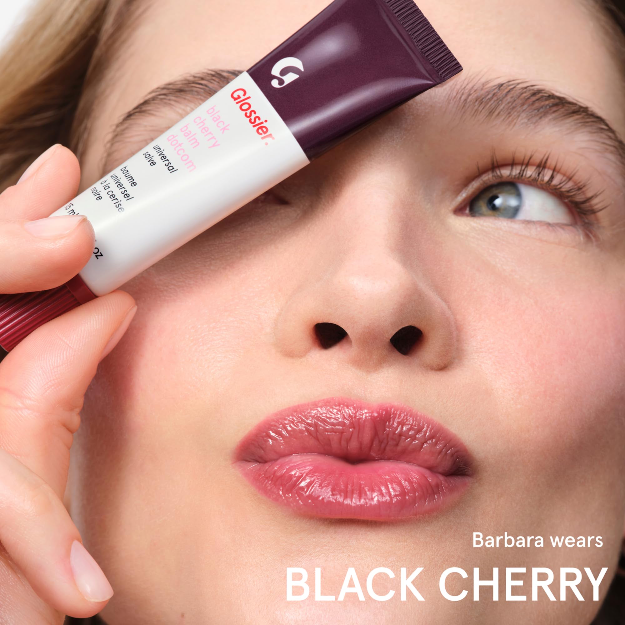 glossier balm dotcom next to common items illustrating portable, travel-friendly size