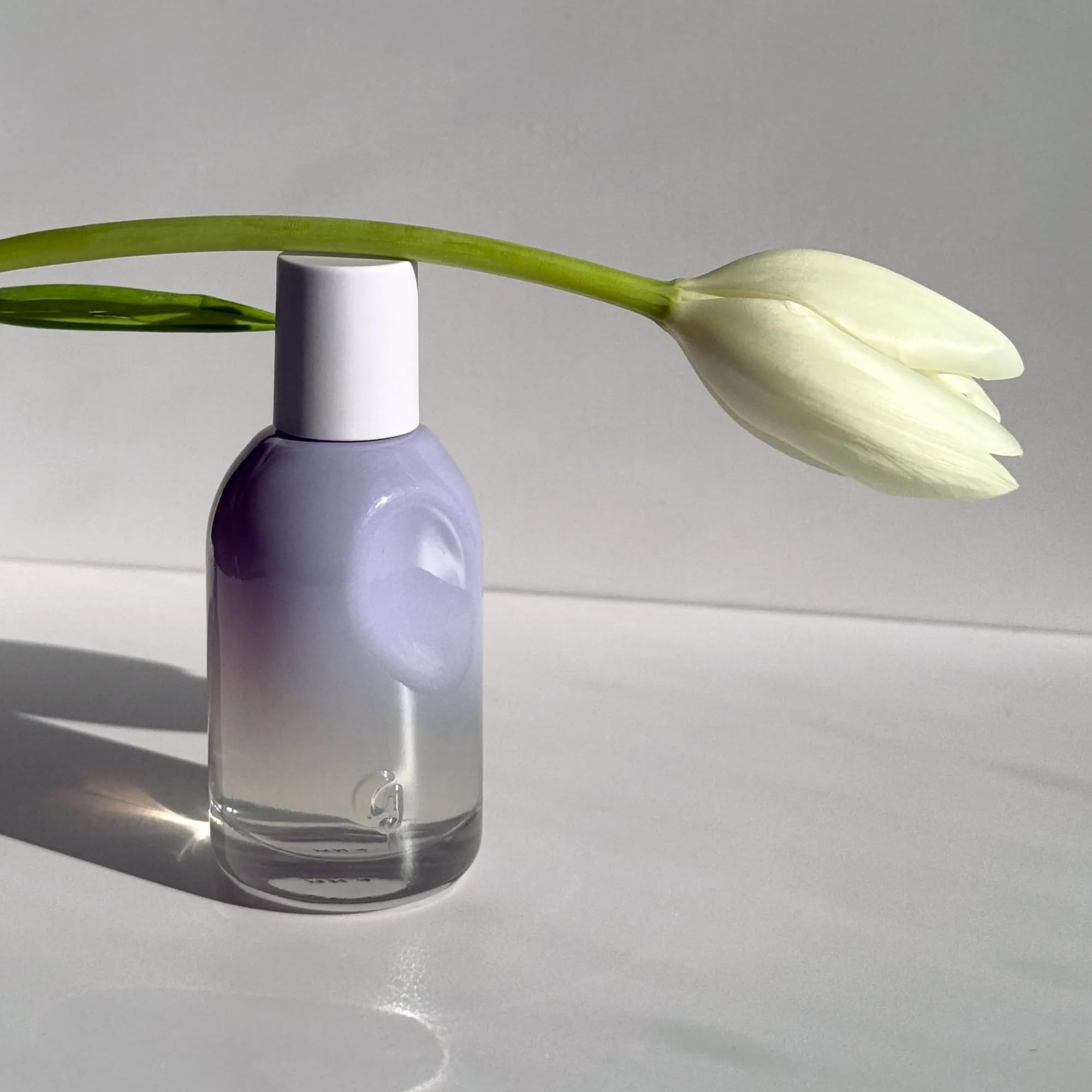 Glossier bottle on dressing table with skincare, suggests daily routine integration benefit