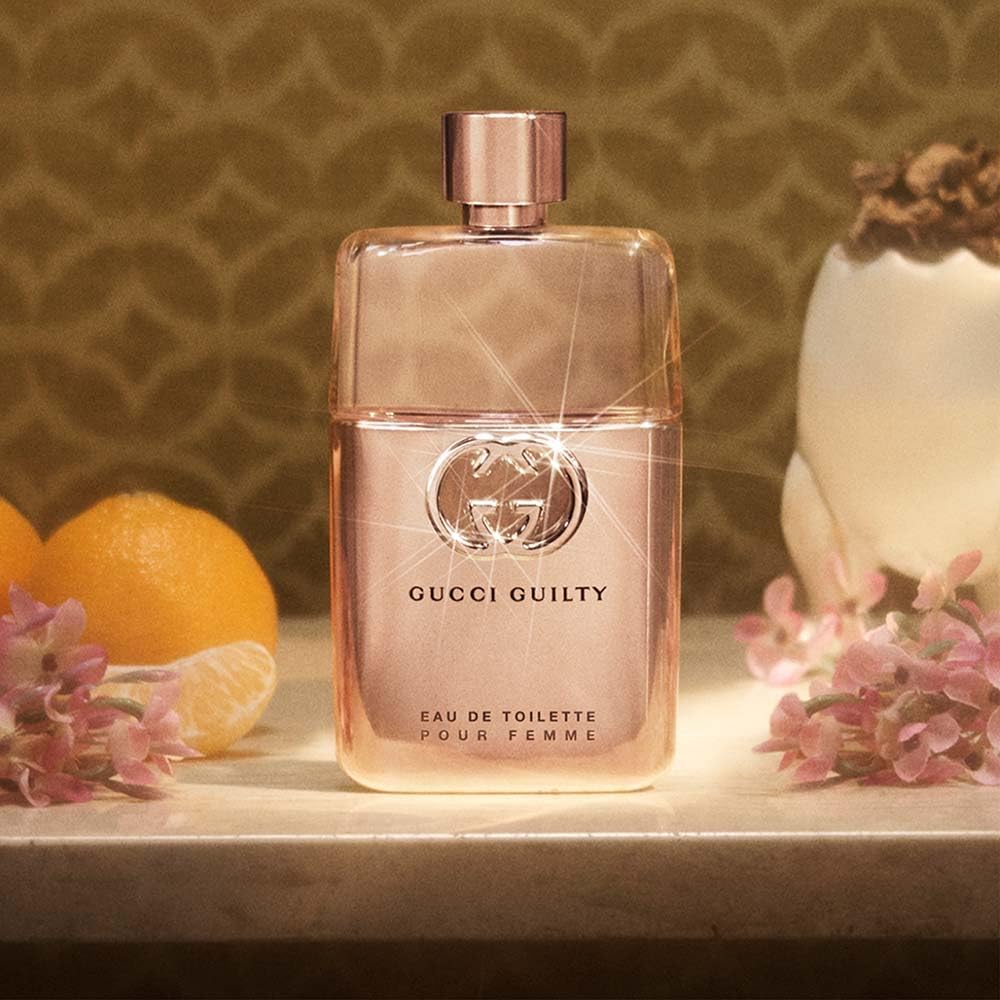 Gucci Guilty bottle beside box in lifestyle scene indicating luxury gifting option