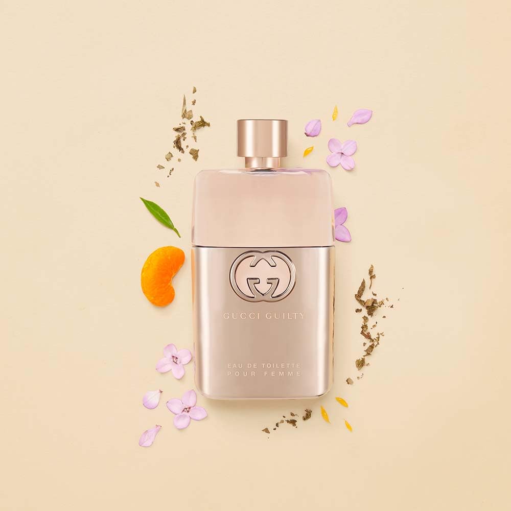 Gucci Guilty bottle held in hand showing 1.6 oz scale for travel-friendly use