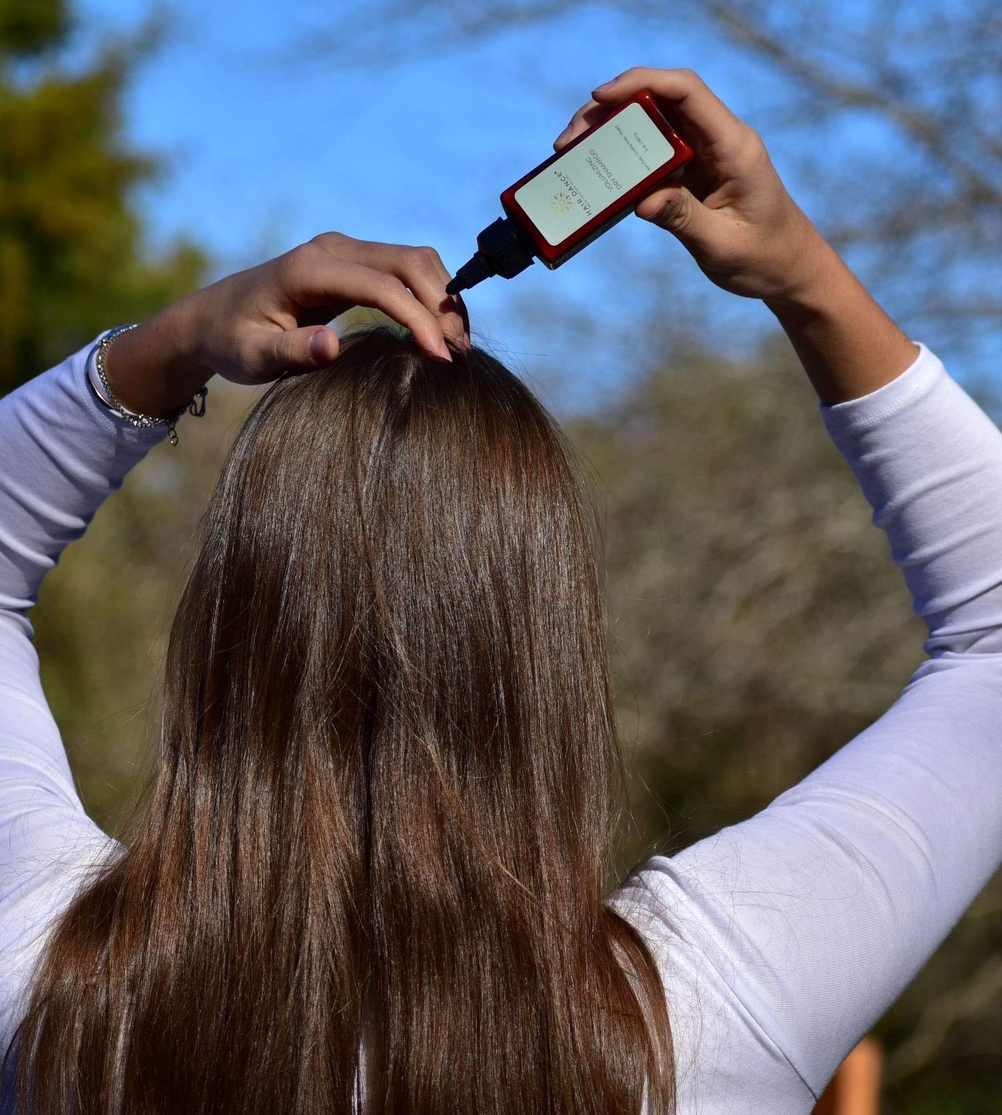 Hair Dance container next to hand illustrating 2oz jumbo portability