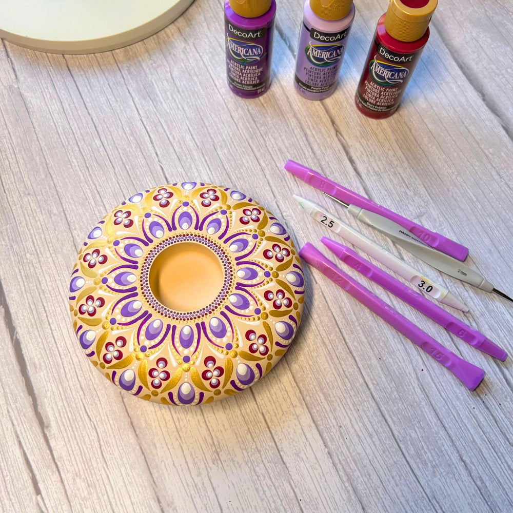 Happy Dotting Company tools beside painted rock to illustrate size and coverage