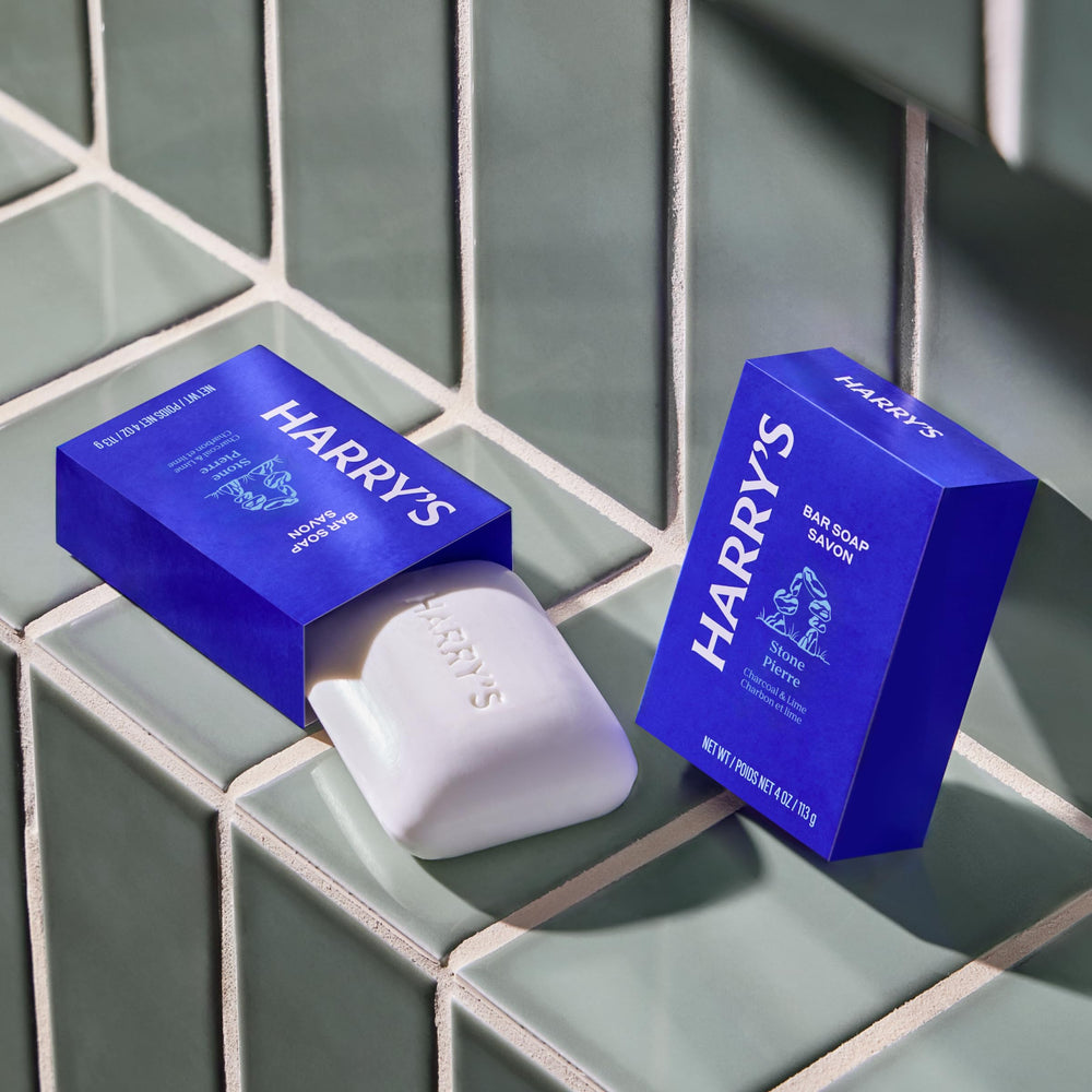 Harry's Stone bar beside coin for scale showing the compact 4 oz size benefit